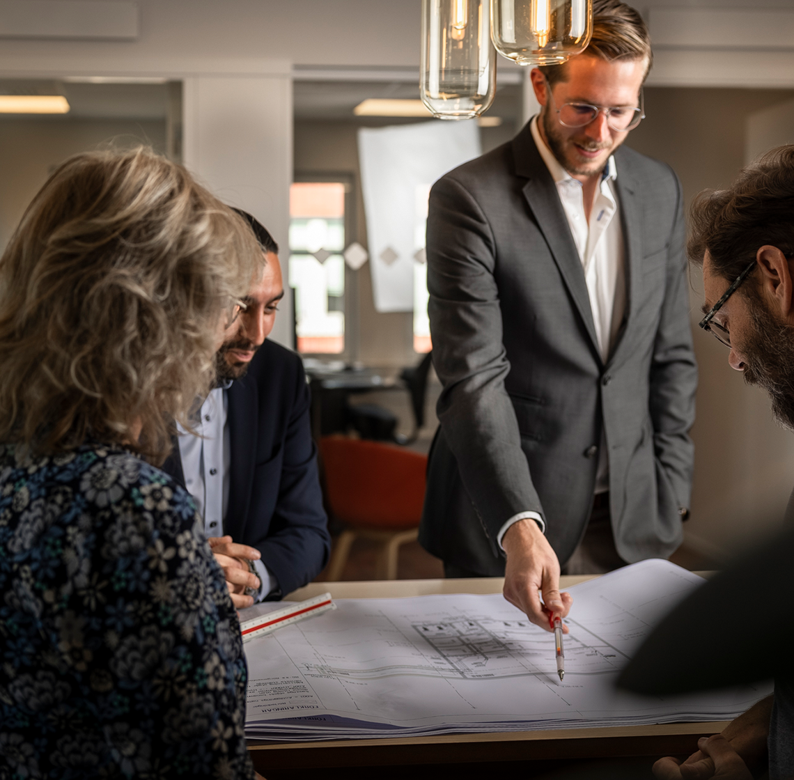 Fyra personer som sitter och tittar på ett stort papper